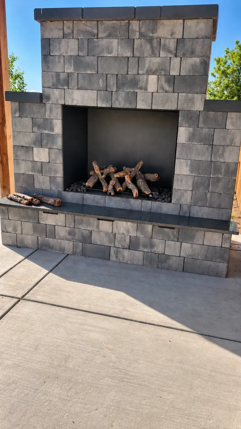 Gray masonry outdoor fireplace with a recessed firebox and patio surround