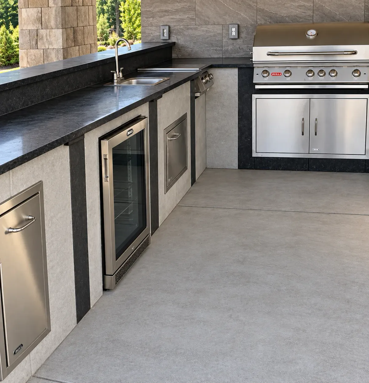Outdoor kitchen with built-in cabinetry, counter space, and a large grill